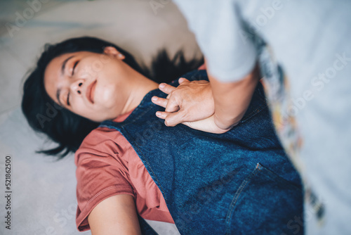 First aids emergency CPR on heart attack woman laying unconscious in home, One part of the process resuscitation - healthcare and insurance concept. photo