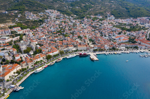 View of the harbor and city. Makarska riviera.Dolmatia.Blue south sea. Mountains, houses, yachts, ships, boats on the pier. City beach and pier. Drone footage. Summer. Adriatic. Relax. Vacation.  © Alexander