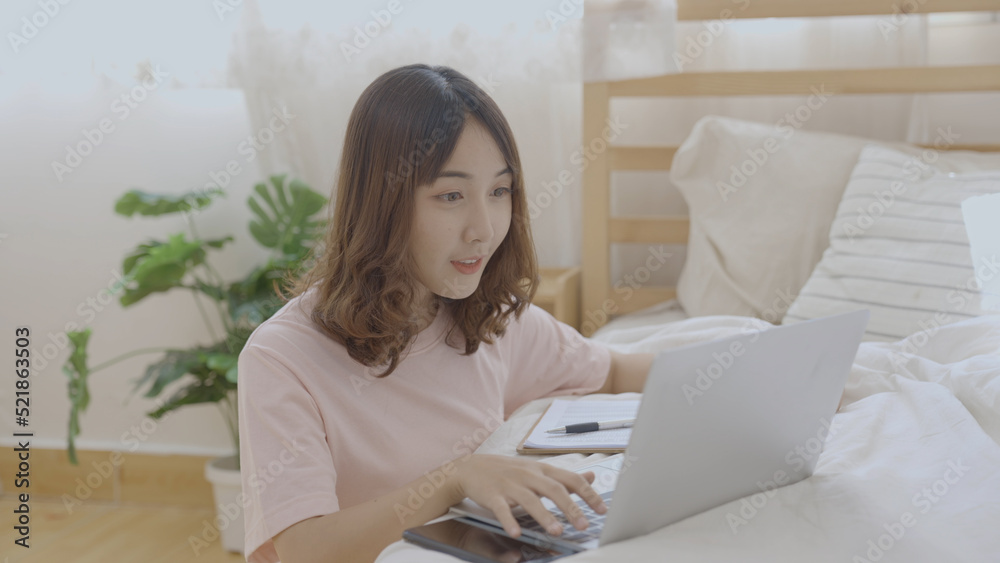 Holiday concept of 4k Resolution. Asian girls working with computers in the bedroom. Holiday concept of 4k Resolution. Asian girls working with computers in the bedroom.