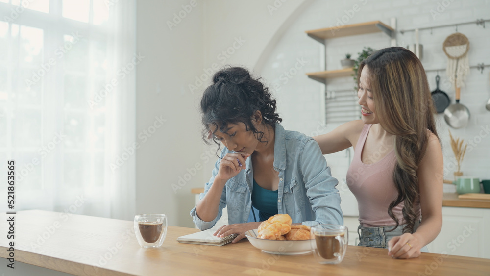 Holiday concept of 4k Resolution. Asian women having coffee together in the kitchen. Young women are in a mutual lesbian love relationship. Holiday concept of 4k Resolution. Asian women having coffee together in the kitchen. Young women are in a mutual lesbian love relationship.