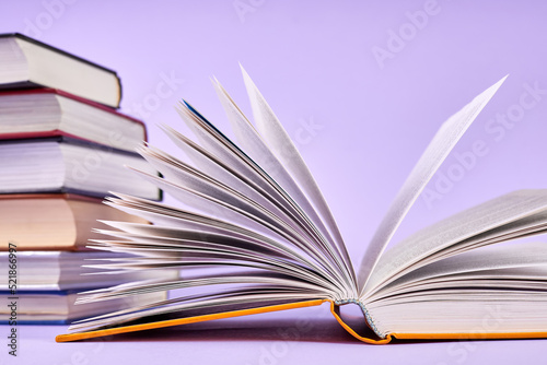 Close-up of an open book on background of a stack of books