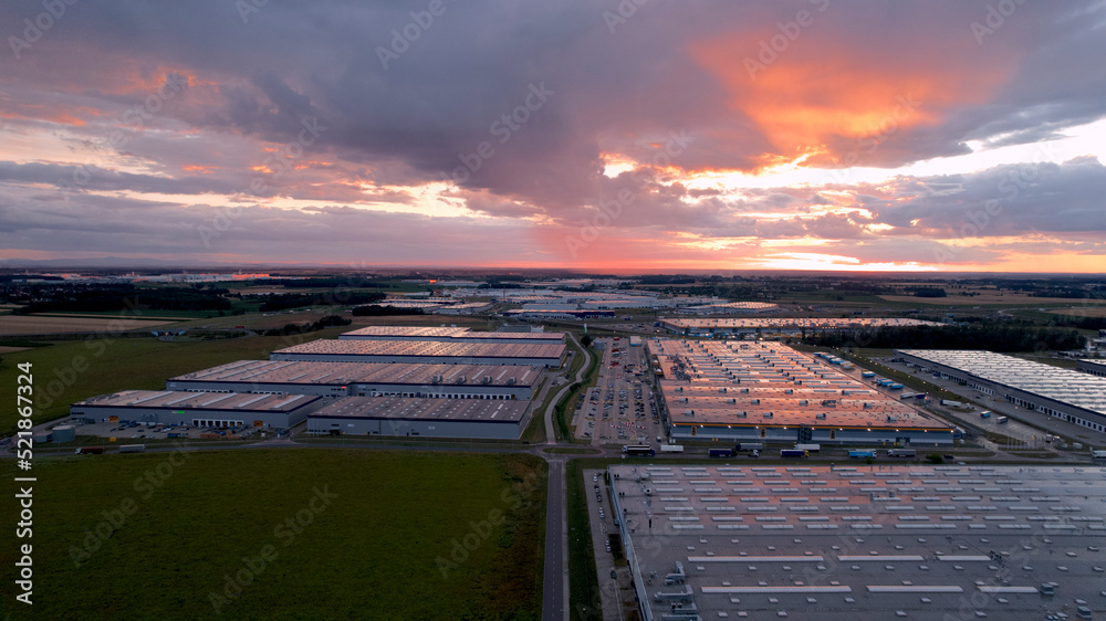 ogromne magazyny centra logistyczne o zachodzie słońca z drona - obrazy, fototapety, plakaty 
