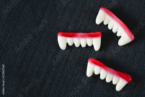 Gummy candy Dracula teeth on a black background with space for copy