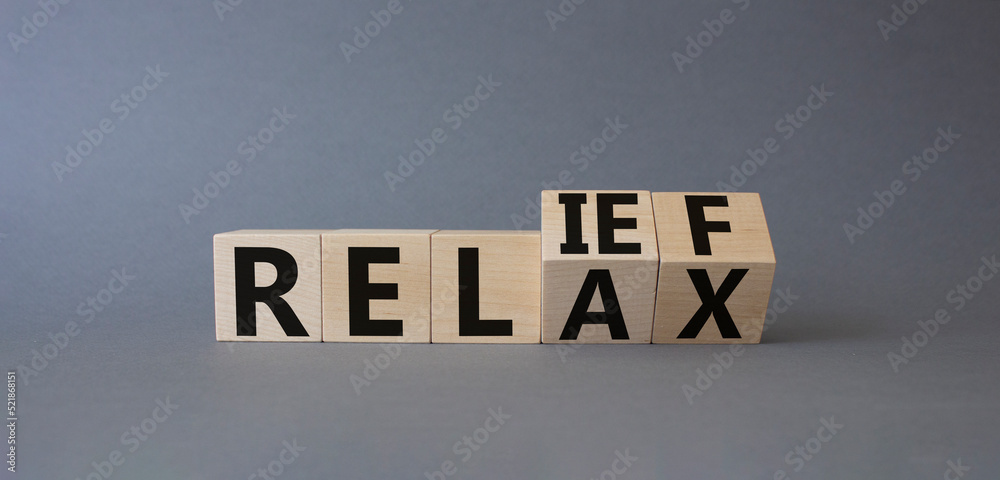 Relief and relax symbol. Turned cubes with words Relief and Relax. Beautiful grey background. Business and Relief and relax concept. Copy space Relief and relax symbol. Turned cubes with words Relief and Relax. Beautiful grey background. Business and Relief and relax concept. Copy space