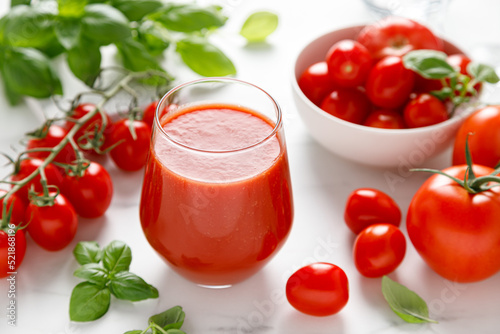 Foto Tomato juice in a glass and fresh tomatoes