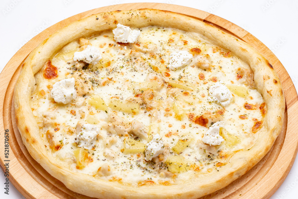 Delicious pizza with pineapple, chicken and ricotta cheese served on a wooden plate. Top view. Delicious pizza with pineapple, chicken and ricotta cheese served on a wooden plate. Top view.