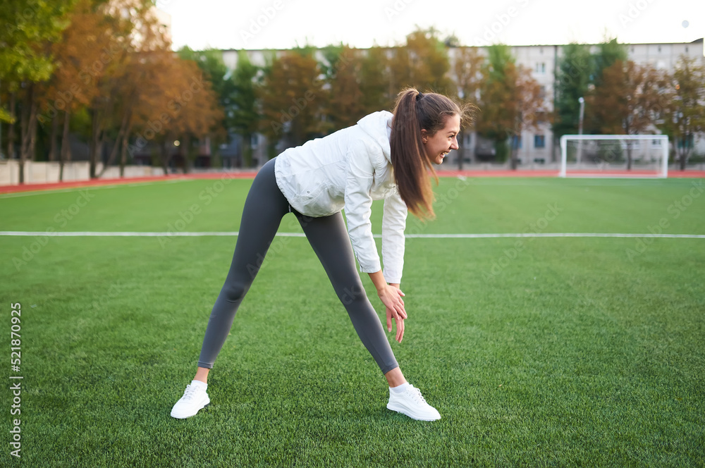 Obraz premium Athletic woman stretching her leg