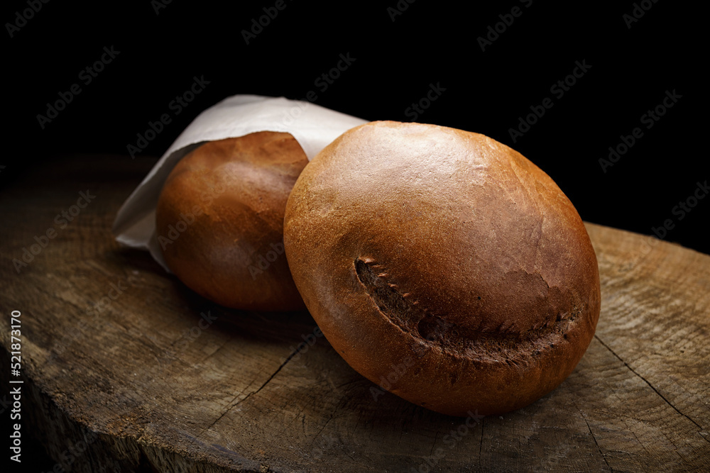Obraz premium Dark round bread on a wooden board