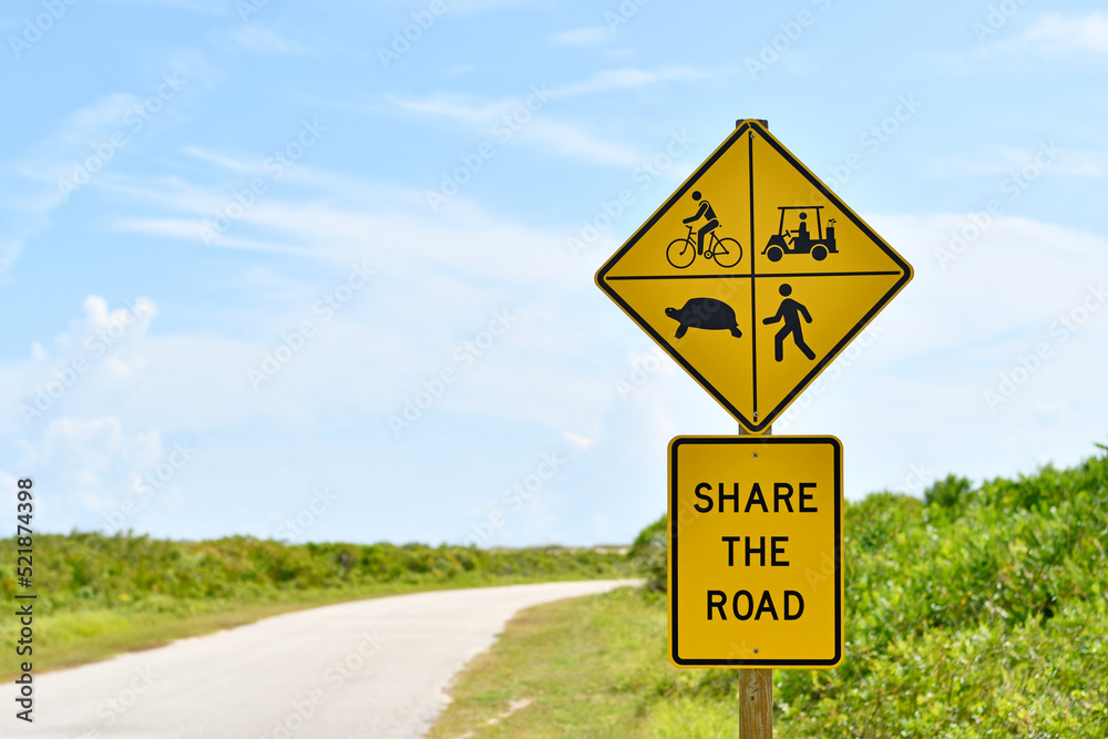 Yellow share the road sign with bicycles, golf carts, turtles, and pedestrians 