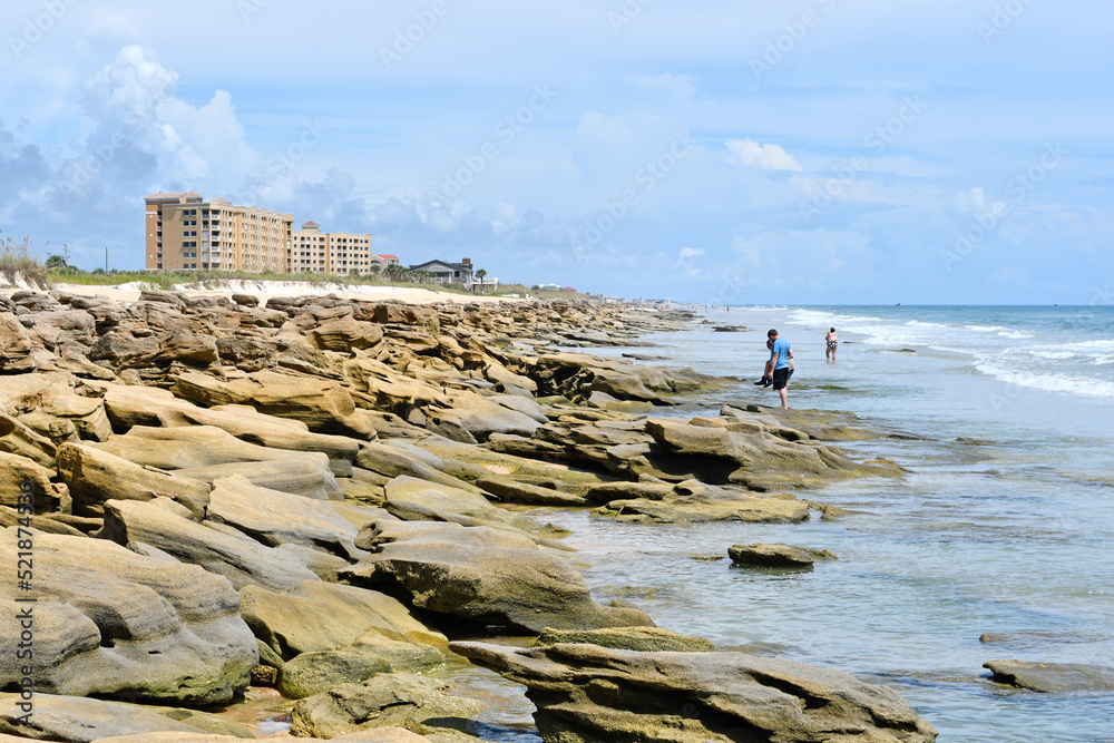Coquina rocks on the beach with condo near Washington Oaks Gardens ...
