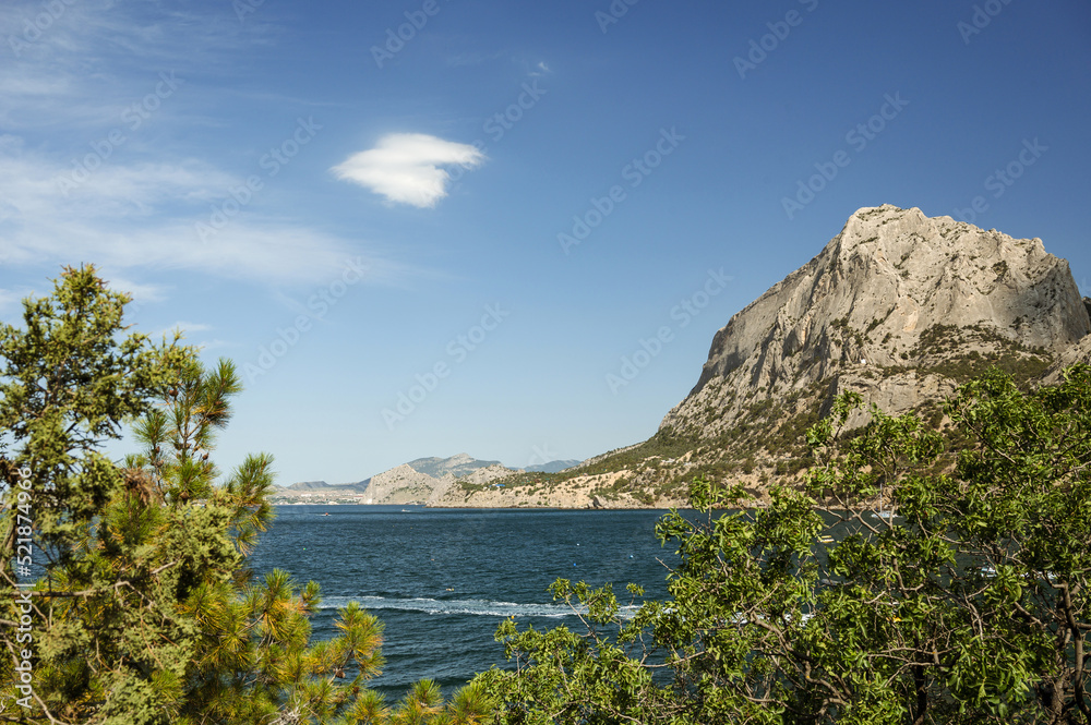 Scenic landscape of blue sea, mountains and green trees. Beautiful summer nature of Crimea. The village of Novy Svet.