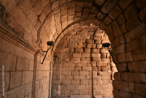 Barrel vaulted access tunnel to Merida Roman theatre, lined by elegant sandstone blocks and iron torches still amazes by serene simplicity 2000 years after construction, Mérida, Spain photo