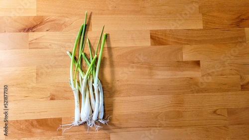 Messy Bunch of Green Onions On Oak Wood Background