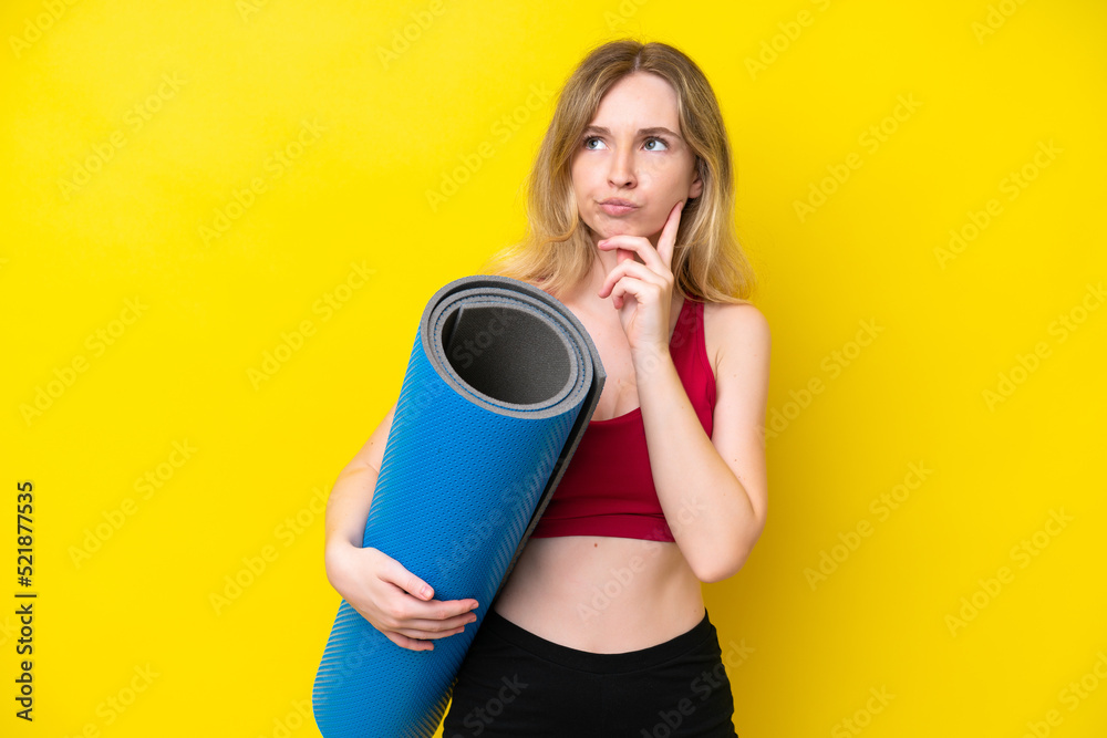 Young sport caucasian woman going to yoga classes while holding a mat isolated on yellow background having doubts Young sport caucasian woman going to yoga classes while holding a mat isolated on yellow background having doubts