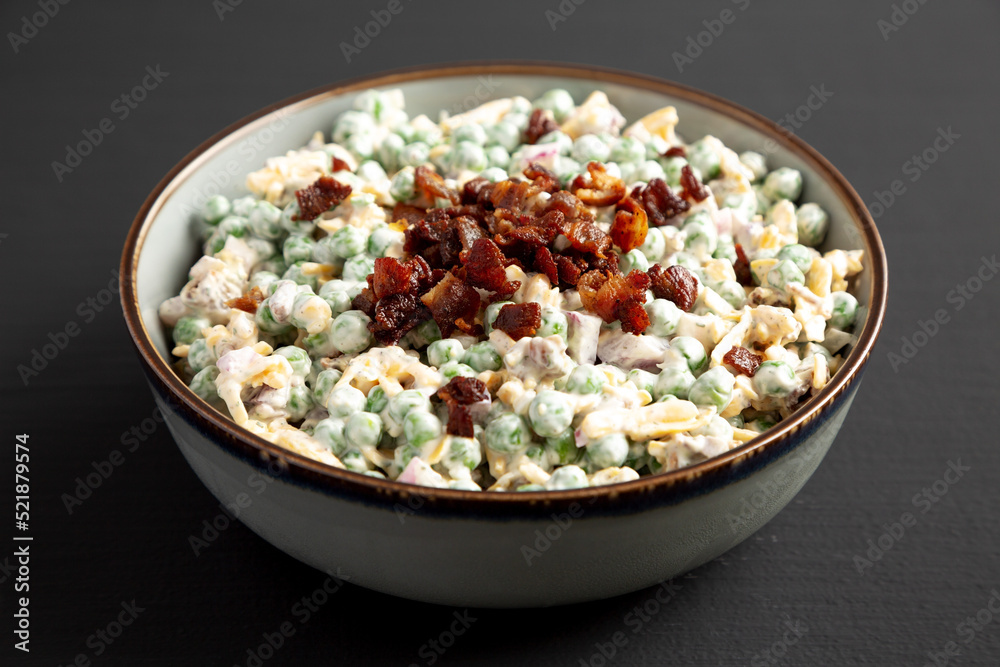 Homemade Creamy Bacon Pea Salad in a Bowl on a black background, side view. Homemade Creamy Bacon Pea Salad in a Bowl on a black background, side view.
