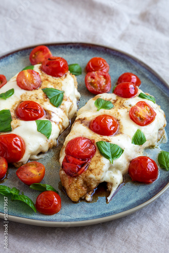 Homemade Caprese Chicken Parmesan with tomato, mozzarella and basil on a Plate, low angle view.
