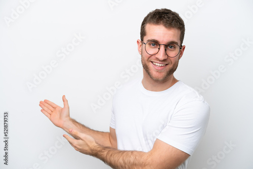 Young caucasian man isolated on white background With glasses and presenting something © luismolinero
