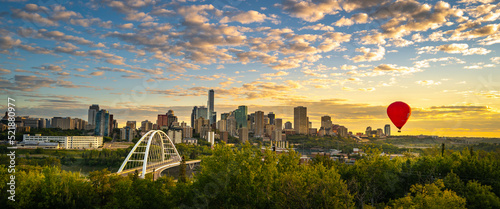 Edmonton cityscape and skyline with the view of a red hot air balloon over Walterdale Bridge in Alberta, Canada. Sunrise city landscape and cloudscape at Queen Elizabeth Park