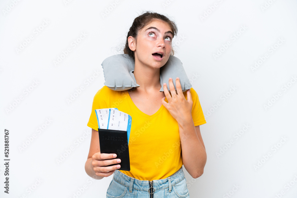 Young caucasian woman with Inflatable travel pillow isolated on white background looking up and with surprised expression Young caucasian woman with Inflatable travel pillow isolated on white background looking up and with surprised expression