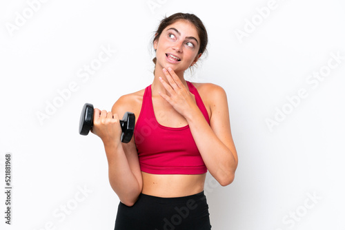 Young sport caucasian woman making weightlifting isolated on white background looking up while smiling