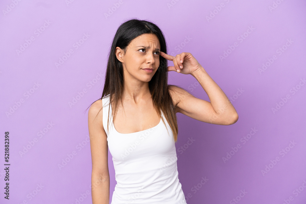 Young caucasian woman isolated on purple background making the gesture of madness putting finger on the head Young caucasian woman isolated on purple background making the gesture of madness putting finger on the head