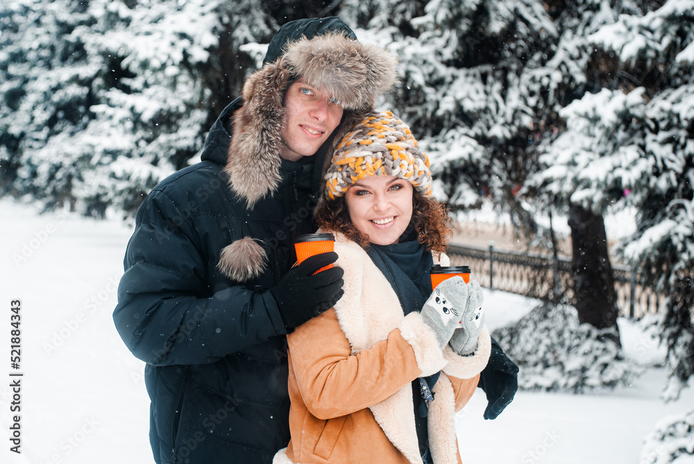 Obraz premium Young beautiful couple in winter forest. Happy couple has fun with snow.