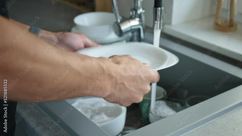 Man washing ditry dishes in kitchen sink near window, Daily routine chores and housework Man washing ditry dishes in kitchen sink near window, Daily routine chores and housework