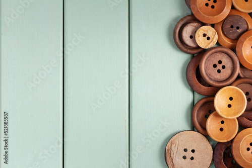 Clothing sewing button on wooden background. Heap of wood buttons on tabletop