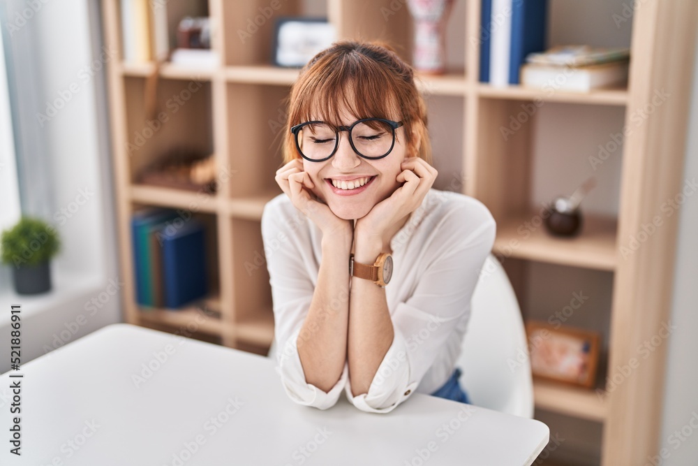 Young woman smiling confident sitting on table at home Young woman smiling confident sitting on table at home
