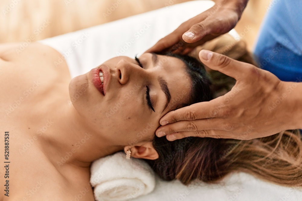Woman reciving head massage at beauty center.