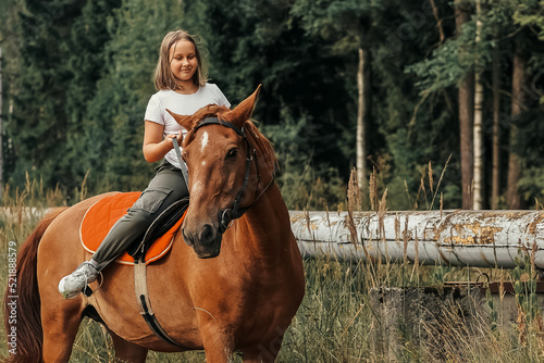 A girl rides a horse in the hot summer in the forest © Enigma