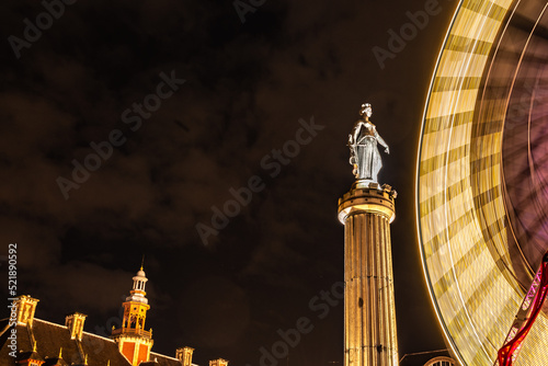 ferris wheel at night with statue in europe