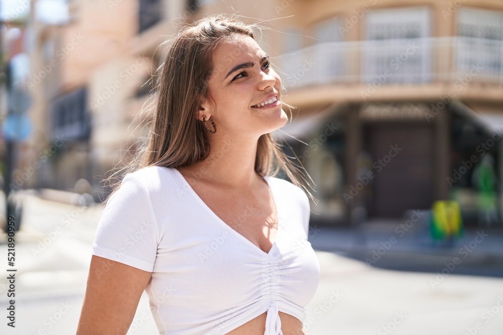 Young woman smiling confident looking to the sky at street Young woman smiling confident looking to the sky at street