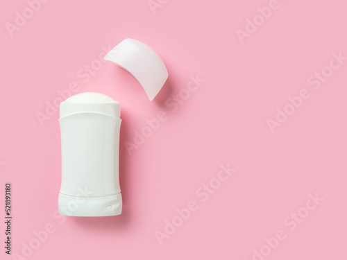 Solid antiperspirant over pink background with copy space. Open white plastic tube of body deodorant close-up. Toiletries for reduce perspiration, hygiene and body care concepts. photo