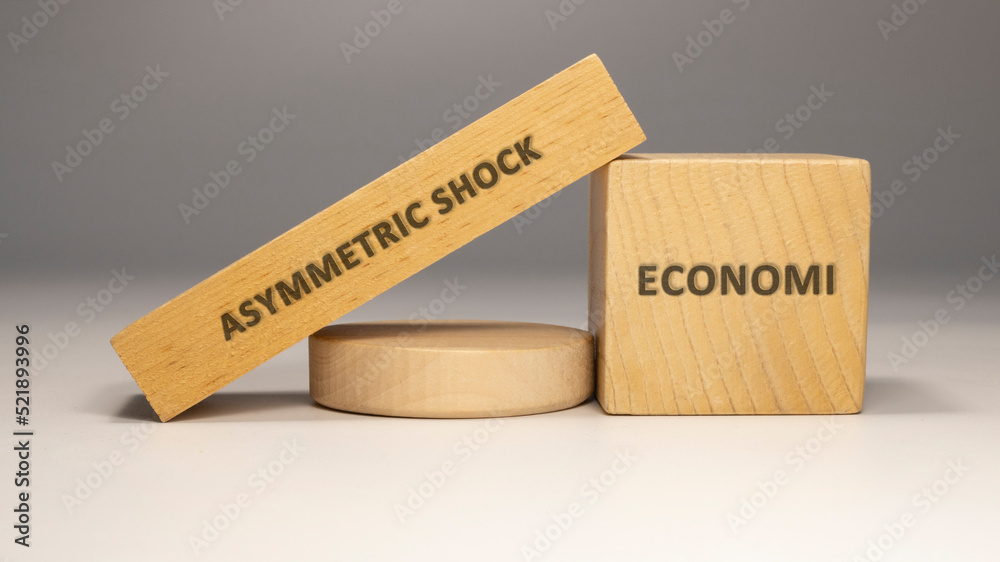 Asymmetric shock was written on the wooden surface. economy and business.