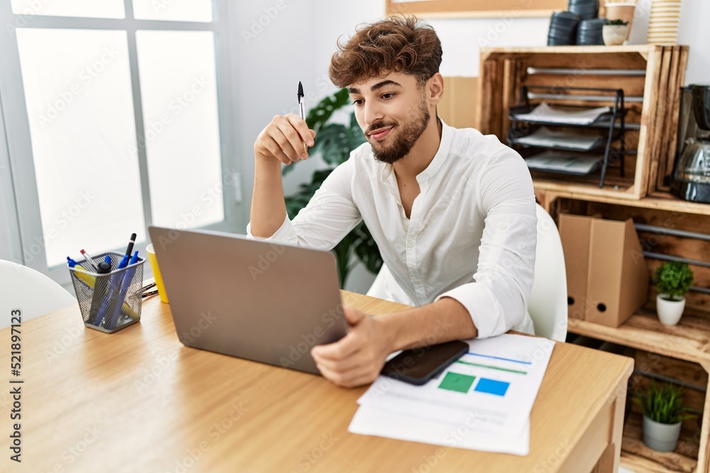 Young arab man using laptop working at office Young arab man using laptop working at office
