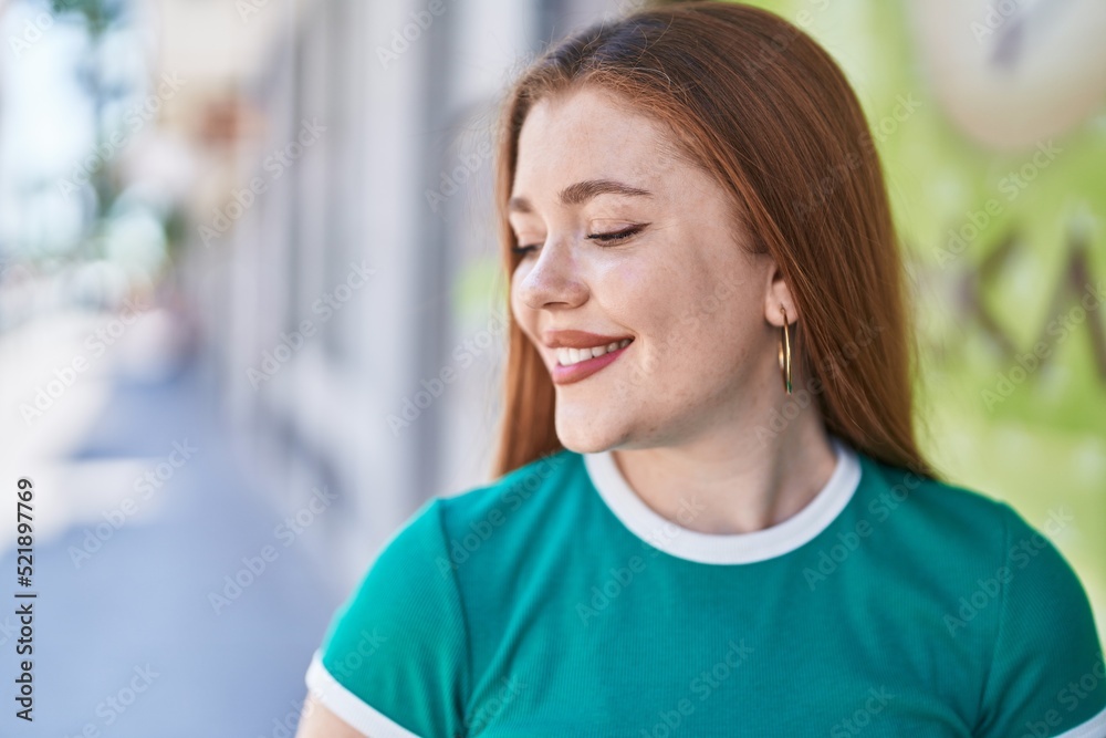 Young redhead woman smiling confident looking to the side at street