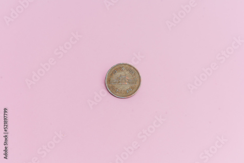 Moneda china de 10 yuanes, sobre un fondo rosa.