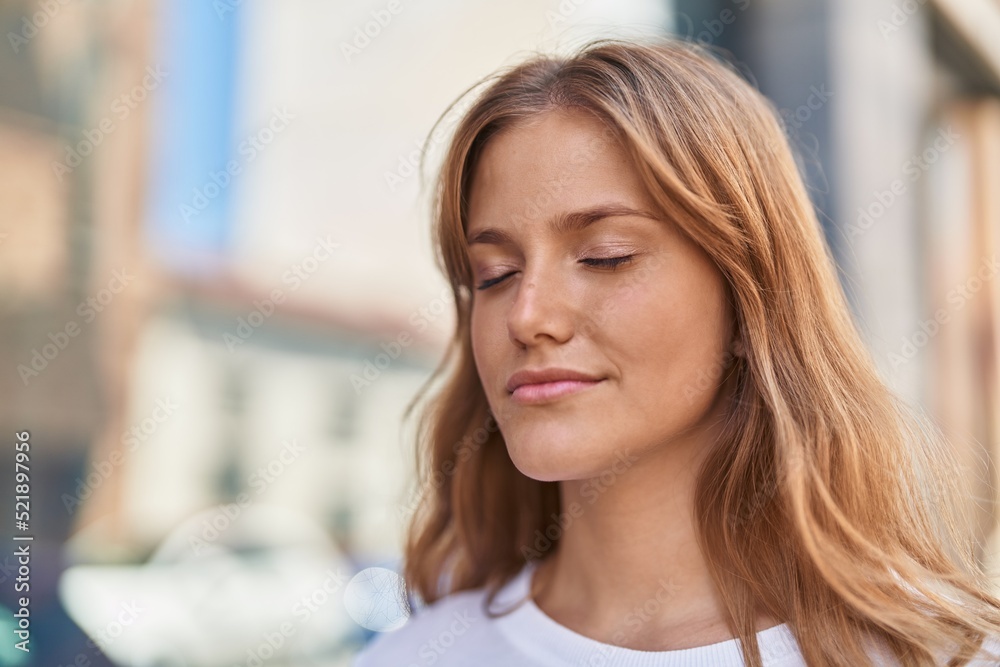 Young blonde girl smiling confident breathing at street