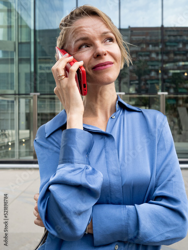 Eastern European business woman talking on the phone in a financial district. Executive woman, entrepreneur woman photo
