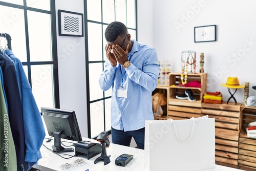 Young african man working as manager at retail boutique with sad expression covering face with hands while crying. depression concept. © Krakenimages.com