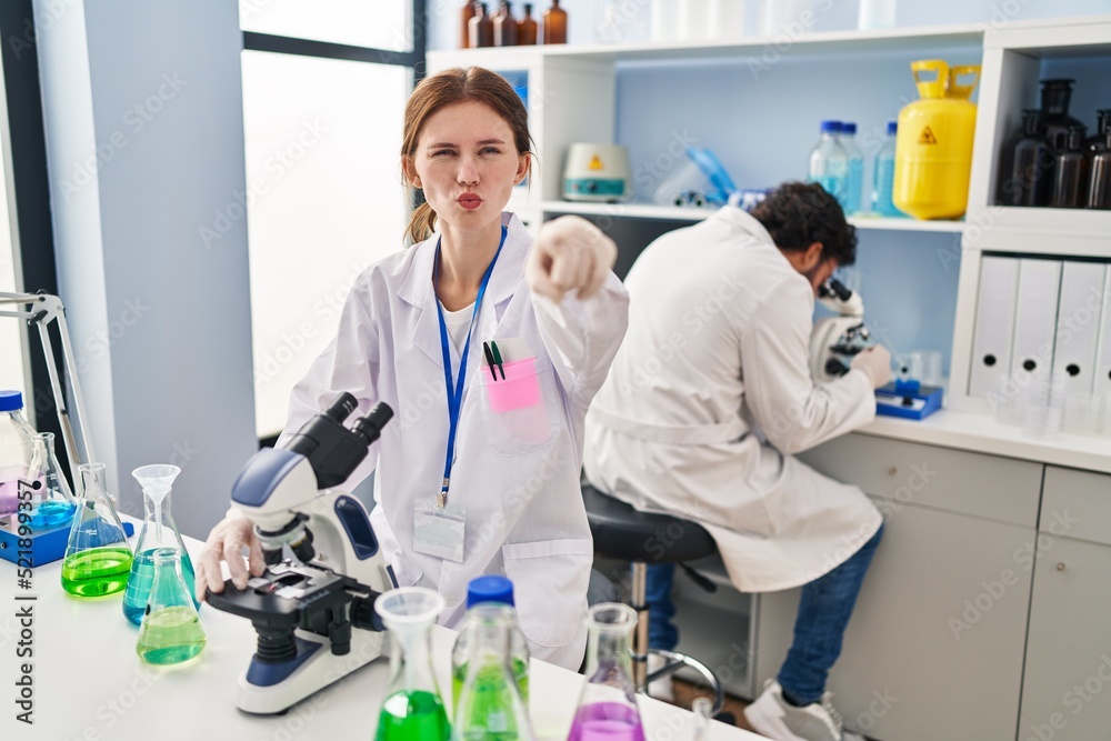 Young two people working at scientist laboratory pointing with finger to the camera and to you, confident gesture looking serious Young two people working at scientist laboratory pointing with finger to the camera and to you, confident gesture looking serious