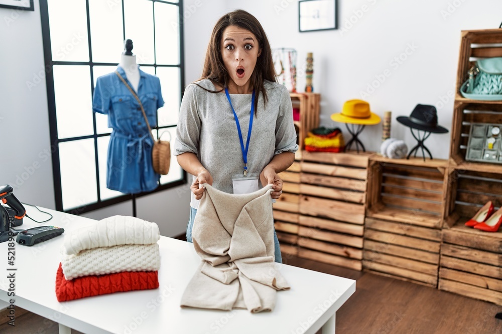 Young brunette woman working at retail boutique afraid and shocked with surprise and amazed expression, fear and excited face. Young brunette woman working at retail boutique afraid and shocked with surprise and amazed expression, fear and excited face.