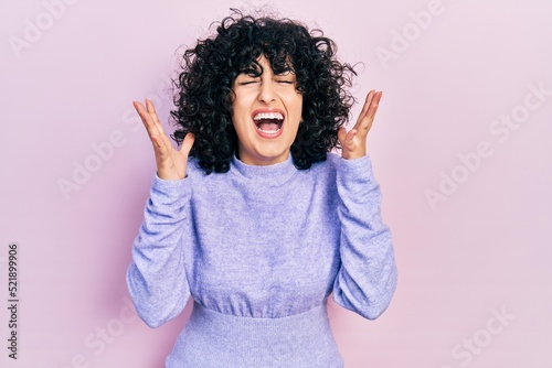 Young middle east woman wearing casual clothes celebrating mad and crazy for success with arms raised and closed eyes screaming excited. winner concept © Krakenimages.com