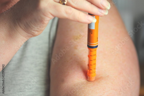 Hypodermic needle being self injected into arm of diabetic patient