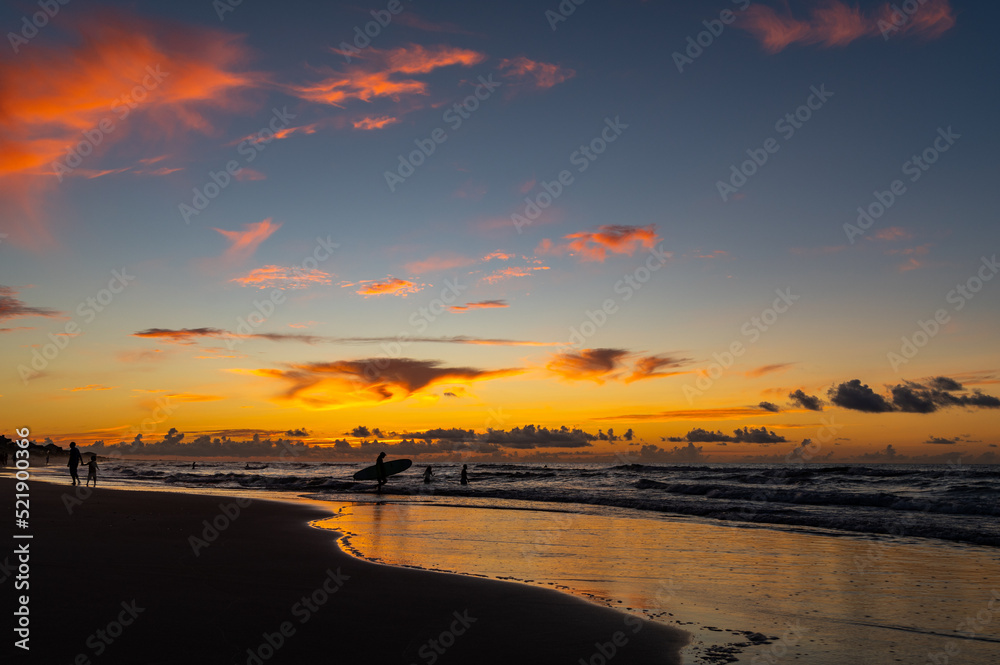 Naklejka premium Heading Out with Surfboard in Morning Twilight