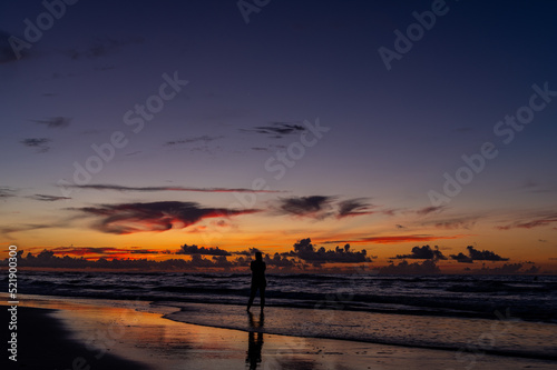 Photographer on Beach during Colorful Twilight