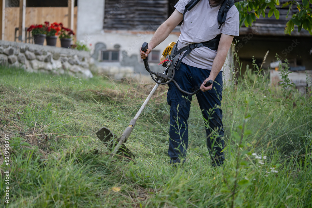 caucasian man farmer using string trimmer to cut grass brush cutter caucasian man farmer using string trimmer to cut grass brush cutter