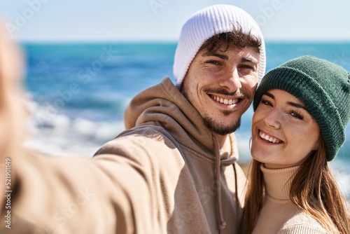 Mand and woman couple hugging each other make selfie by camera at seaside