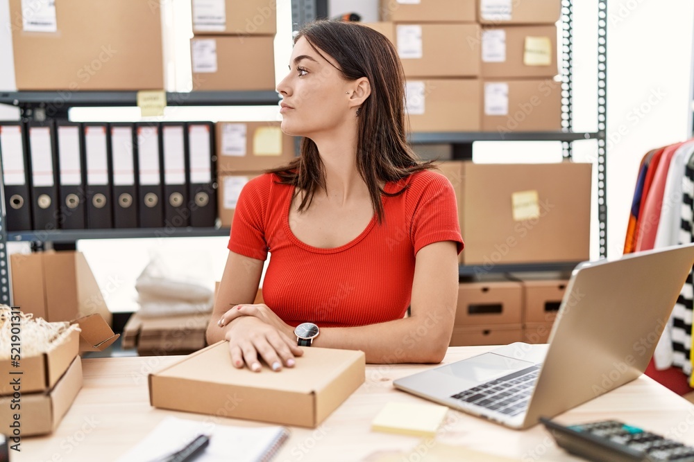 Young hispanic woman preparing order working at storehouse looking to side, relax profile pose with natural face and confident smile. Young hispanic woman preparing order working at storehouse looking to side, relax profile pose with natural face and confident smile.